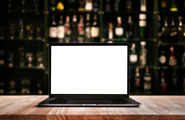 современный компьютер, ноутбук на столе бар с размытием бутылку вина - beer bar counter bar drink стоковые фото и изображения