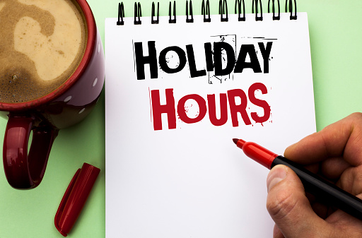 Word writing text Holiday Hours. Business concept for Celebration Time Seasonal Midnight Sales Extra-Time Opening written by Man Notebook Book Holding Marker the plain background Coffee Cup.