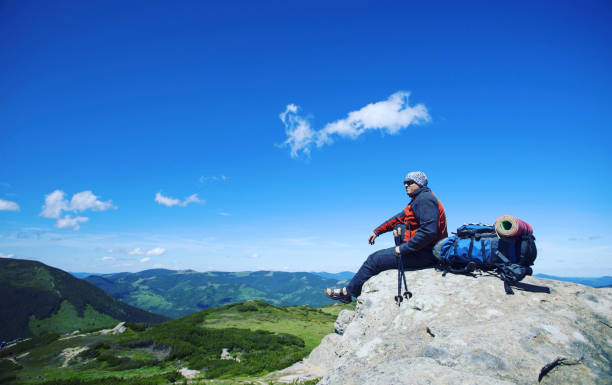istock Summer hike in the mountains with a backpack and tent. 944975596