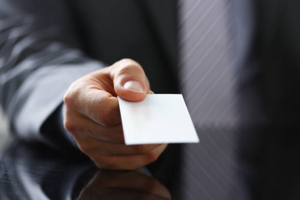 istock Male arm in suit give blank calling card 944975852