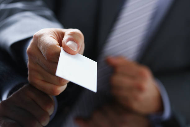 istock Male arm in suit give blank calling card 944975858