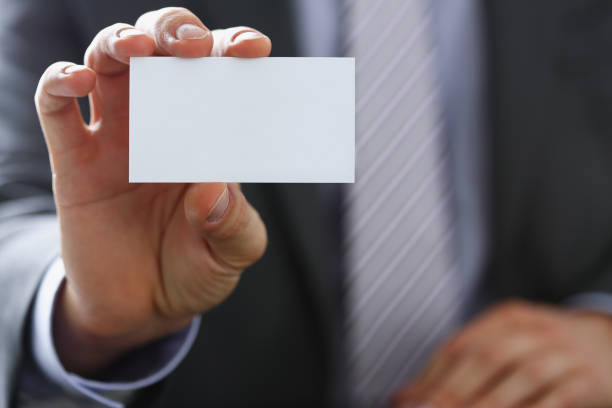 istock Male arm in suit give blank calling card 944975938