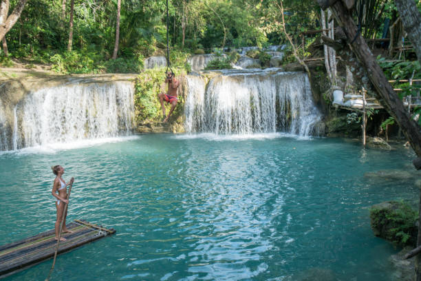 istock Young couple playing at beautiful waterfall in the Philippines 944976510