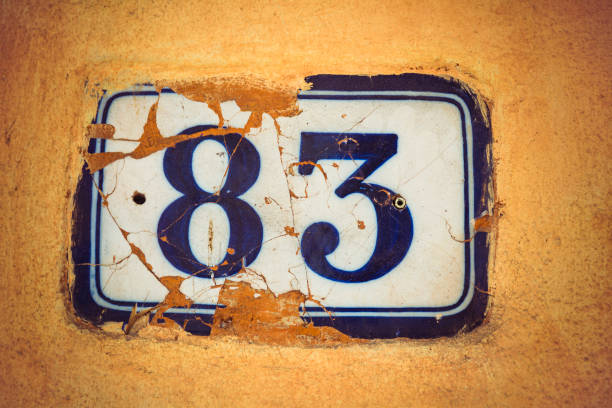 istock Number eighty three enamel door number on plaster wall 944979030