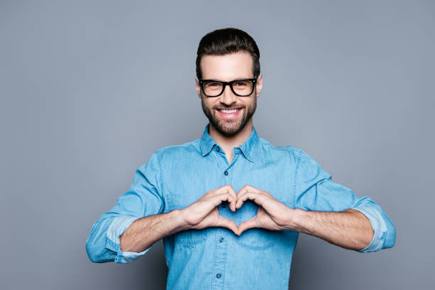 retrato de hombre guapo feliz en gafas haciendo corazón con los dedos - made man object fotografías e imágenes de stock