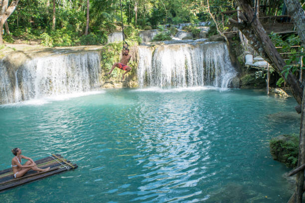 istock Young couple playing at beautiful waterfall in the Philippines 944982812