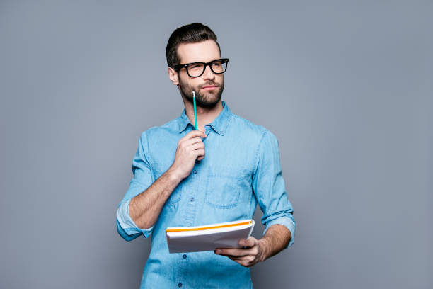istock Young thoughtful bearded man in glasses thinking about test 944983020