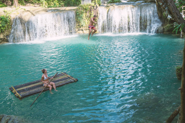 istock Young couple playing at beautiful waterfall in the Philippines 944983414