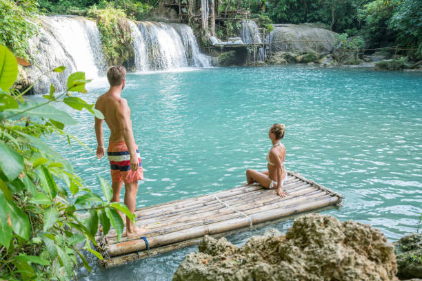 istock Young couple contemplating beautiful waterfall in the Philippines 944983578