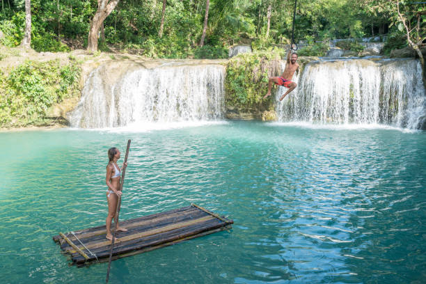istock Young couple playing at beautiful waterfall in the Philippines 944984128