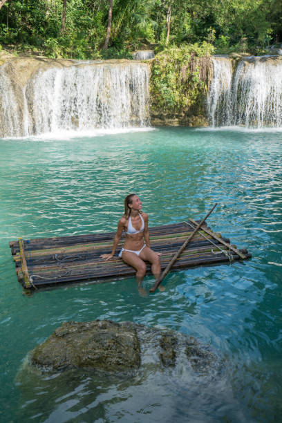 Girl contemplating beautiful waterfall in the Philippines Young woman contemplating a beautiful waterfall on Siquijor Island in the Philippines. People travel nature loving concept. One person only enjoying outdoors and tranquillity in a peaceful environment, solo traveler concept siquijor stock pictures, royalty-free photos & images