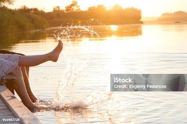 Una Coppia Di Amanti Si Siede Sul Ponte - Fotografie stock e altre immagini di Lago - Lago, Fiume, Tramonto