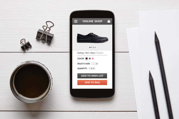 istock Online shop concept on smart phone screen on white wooden table 944988304