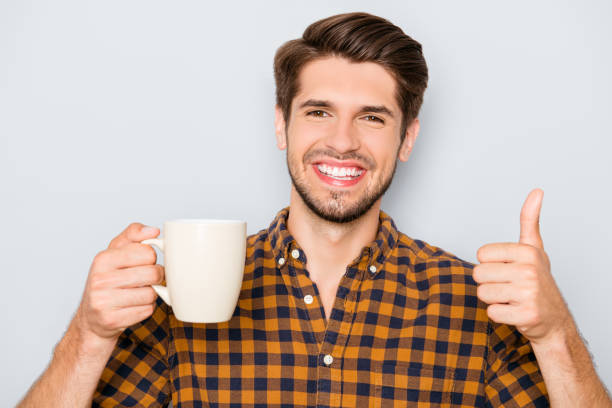 istock Happy cheerful man with cup of tea gesturing like 944990270