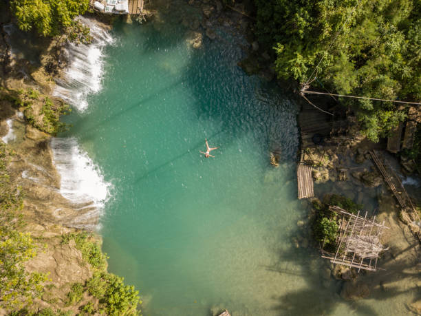 istock Young woman floating in star shape at waterfall in rainforest 944990616