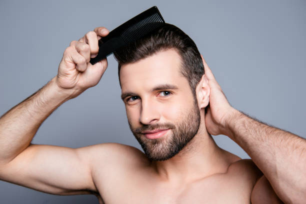 istock Portrait  of young handsome man combing his hair 944992004
