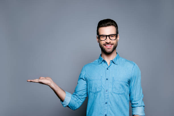 alegre homem barbudo de óculos fazendo propaganda do novo produto - showing hands - fotografias e filmes do acervo