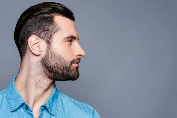 Side view of young stylish man isolated on gray background Side view of young stylish man isolated on gray background stubble stock pictures, royalty-free photos & images