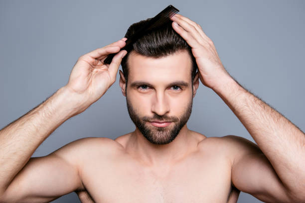 istock Portrait of handsome young guy combing his hair 944995292