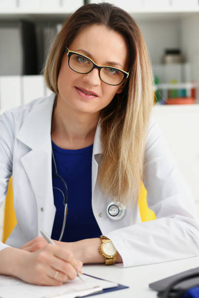 istock Beautiful smiling female doctor sit at workplace 944997354