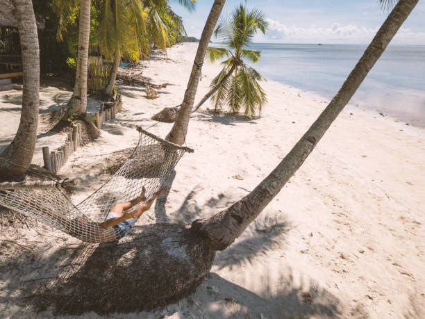 istock Young man relaxing on hammock by the beach, tropical climate 944997540