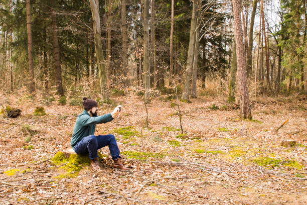 istock man taking photo with smartphone in the forest 945005238