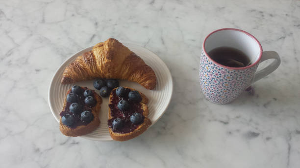 istock Breakfast blueberries toast and croissant with tea cup 945008518