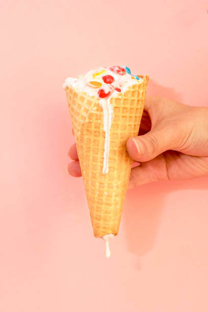 istock Hand holds ice cream that melts and drips in a waffle cone 945009298