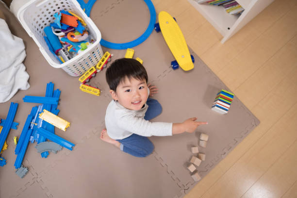 Toddler playing in room with toy Everyday life of toddler in house asian toddler fewer toys stock pictures, royalty-free photos & images