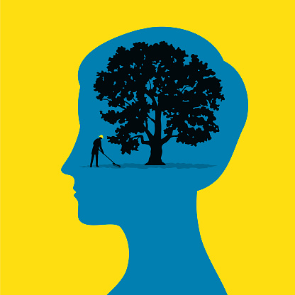 A gardener looks after a tree inside the silhouette of a woman head