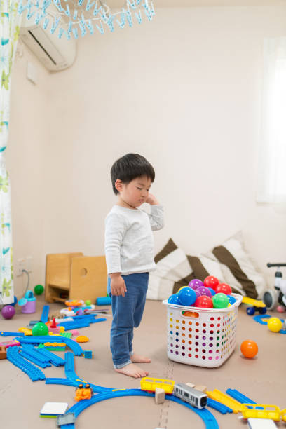 A toddler plays with toys near a basket in a bright, sunlit room. The scene evokes warmth, innocence, and the joy of early childhood experiences.