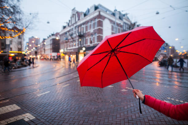 Woman with umbrella having fun in rainy day