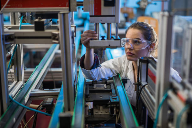 Quality control worker analyzing machine part in laboratory. Female engineer examining machine part on a production line. stem research stock pictures, royalty-free photos & images