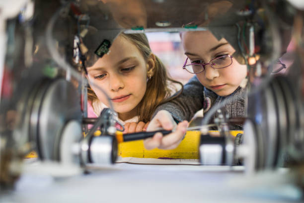 istock Two little engineers working in team while repairing a robot. 945023608