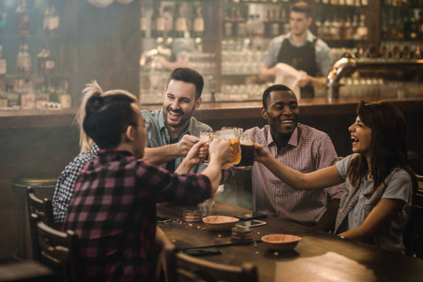 istock Group of happy friends having fun while toasting with beer in a pub. 945026178