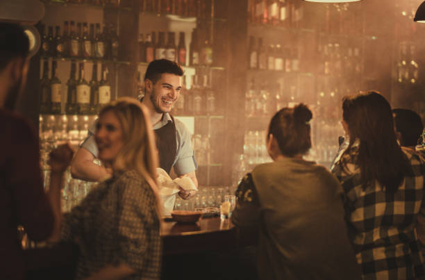 szczęśliwy barman rozmawia ze swoimi klientami w pubie. - spring cleaning women cleaning dancing zdjęcia i obrazy z banku zdjęć