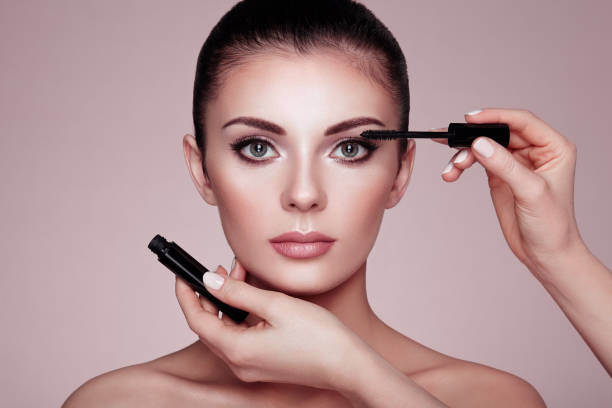 istock Beautiful brunette woman paints the eyelashes 945031764