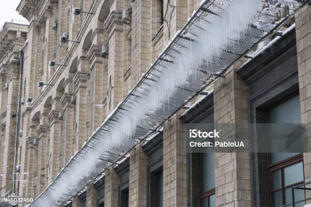Icicles On A Grid Under The Building At Winter Stock Photo - Download Image Now - Building Exterior, Built Structure, Care