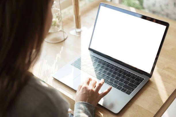 istock Women using laptop with blank screen at table in the office. 945033532