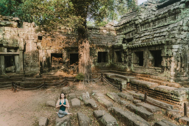 istock Woman doing yoga in  Ta Prohm temple 945037054