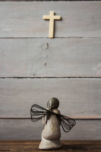 istock angel and cross on wooden background 945037794