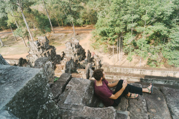 istock Man sitting  in Angkor Temple in Cambodia 945041362