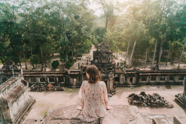Woman  sitting in Angkor temple in Cambodia Young Caucasian woman sitting  in Angkor temple in Siem Reap, Cambodia angkor stock pictures, royalty-free photos & images