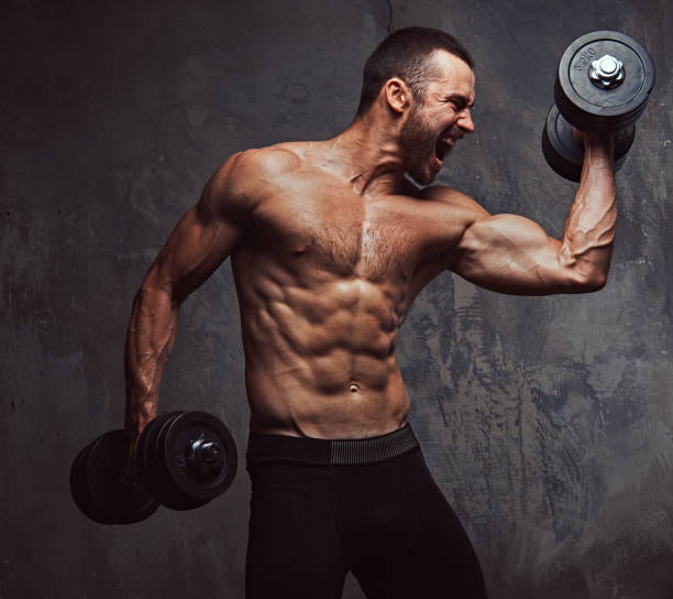 istock Brutal athletic bearded shirtless male doing exercise with dumbb 945042042