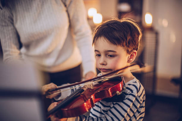 istock Little boy teaching to play violin 945042438