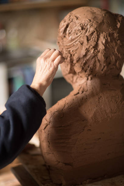 istock Sculptor's hand working on clay bust detail 945044538