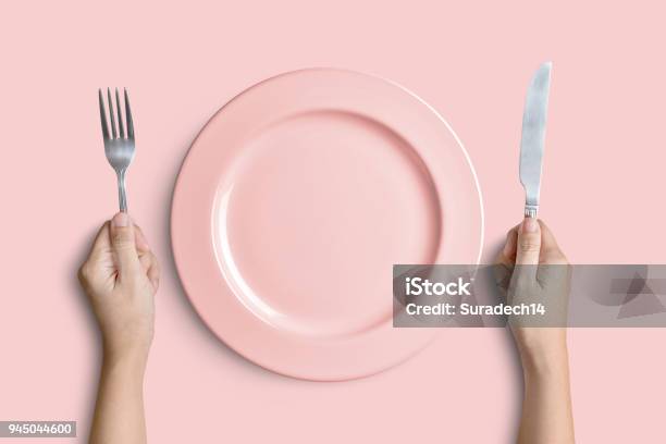 Pink Plate With Silver Fork And Knife On Pink Background Stock Photo - Download Image Now