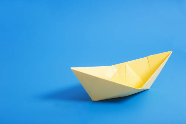 istock paper boat on blue paper background 945045892
