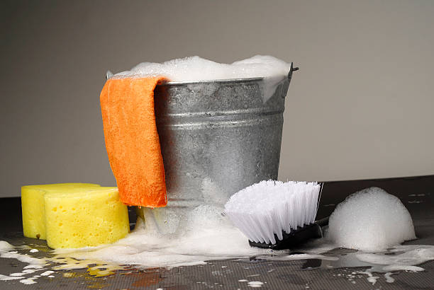 Bucket and Supplies for Car Wash Studio photograph of a bucket of soapy water with yellow sponge, brush and chamois.  bucket and sponge stock pictures, royalty-free photos & images
