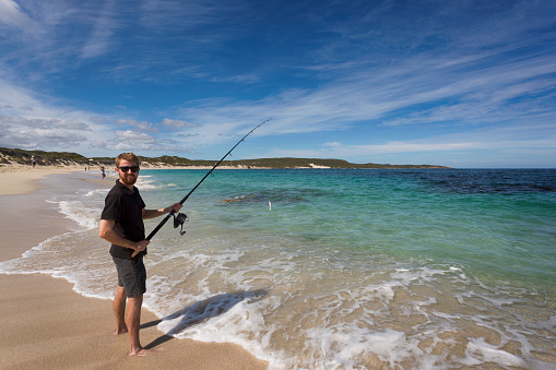 A young adult fishing at Hamelin Bay in Western Australia, a popular destination in Autumn for the Salmon migration.